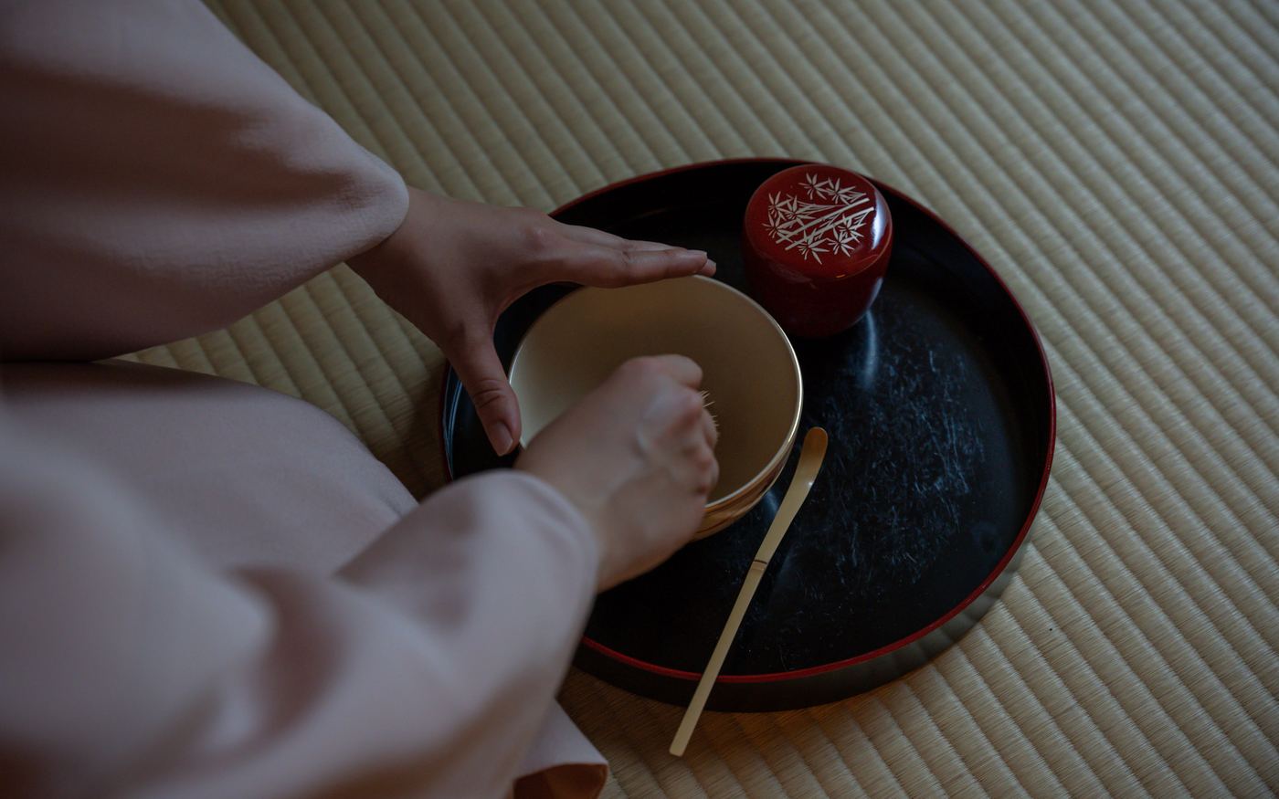 茶を点てる手元と朱の茶器