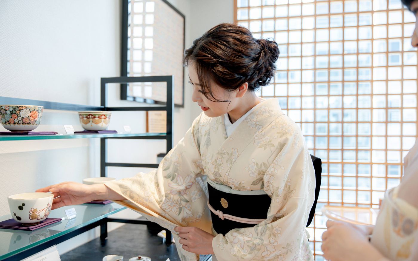 座敷でお茶を運ぶ正絹の着物姿の女性