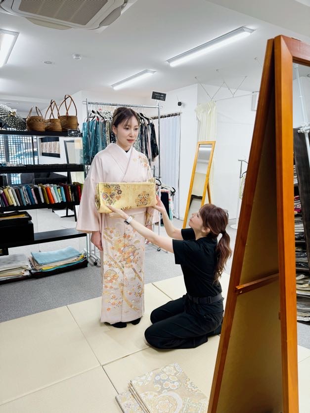 着物に帯を合わせてコーディネートを提案するスタッフ
