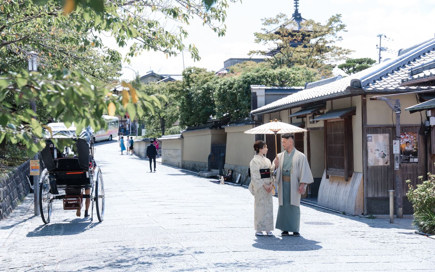 八坂の塔を望む京都の石畳の路地を和傘で歩く着物姿のカップル
