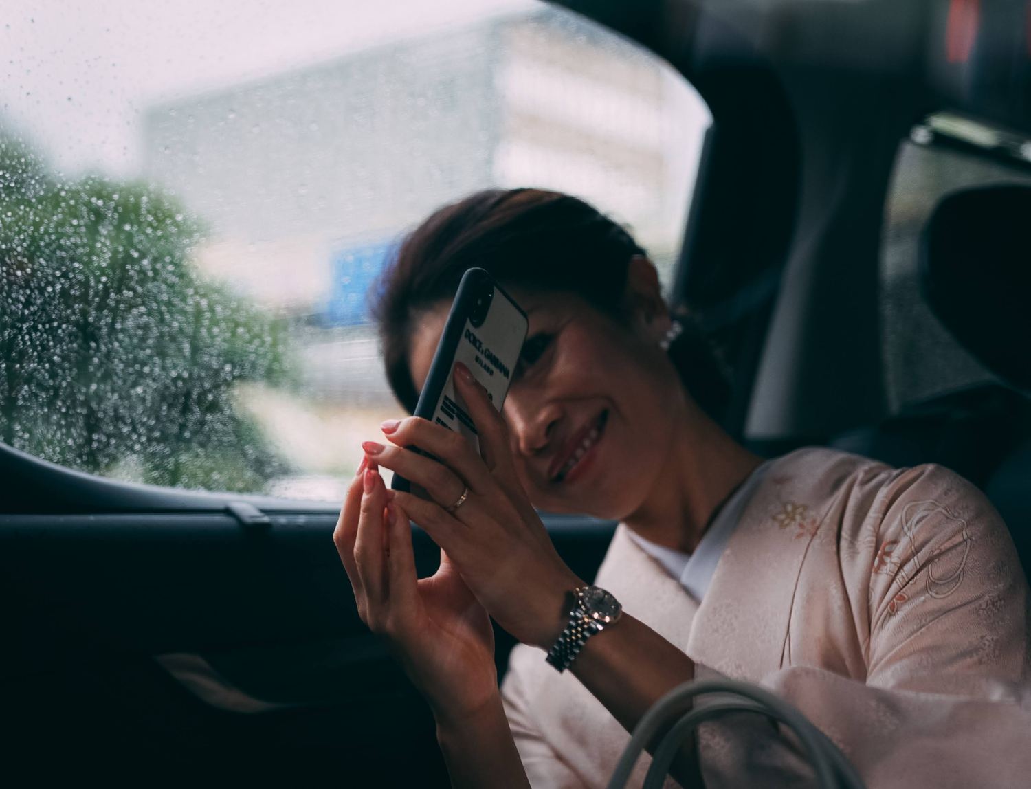 雨の車窓を撮る着物姿の女性