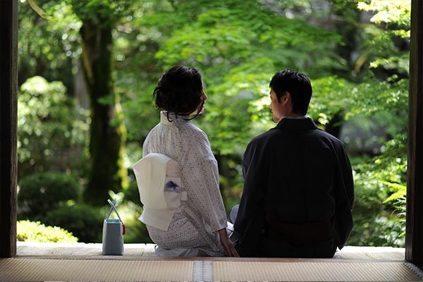 縁側に並んで庭を眺める着物姿のふたり