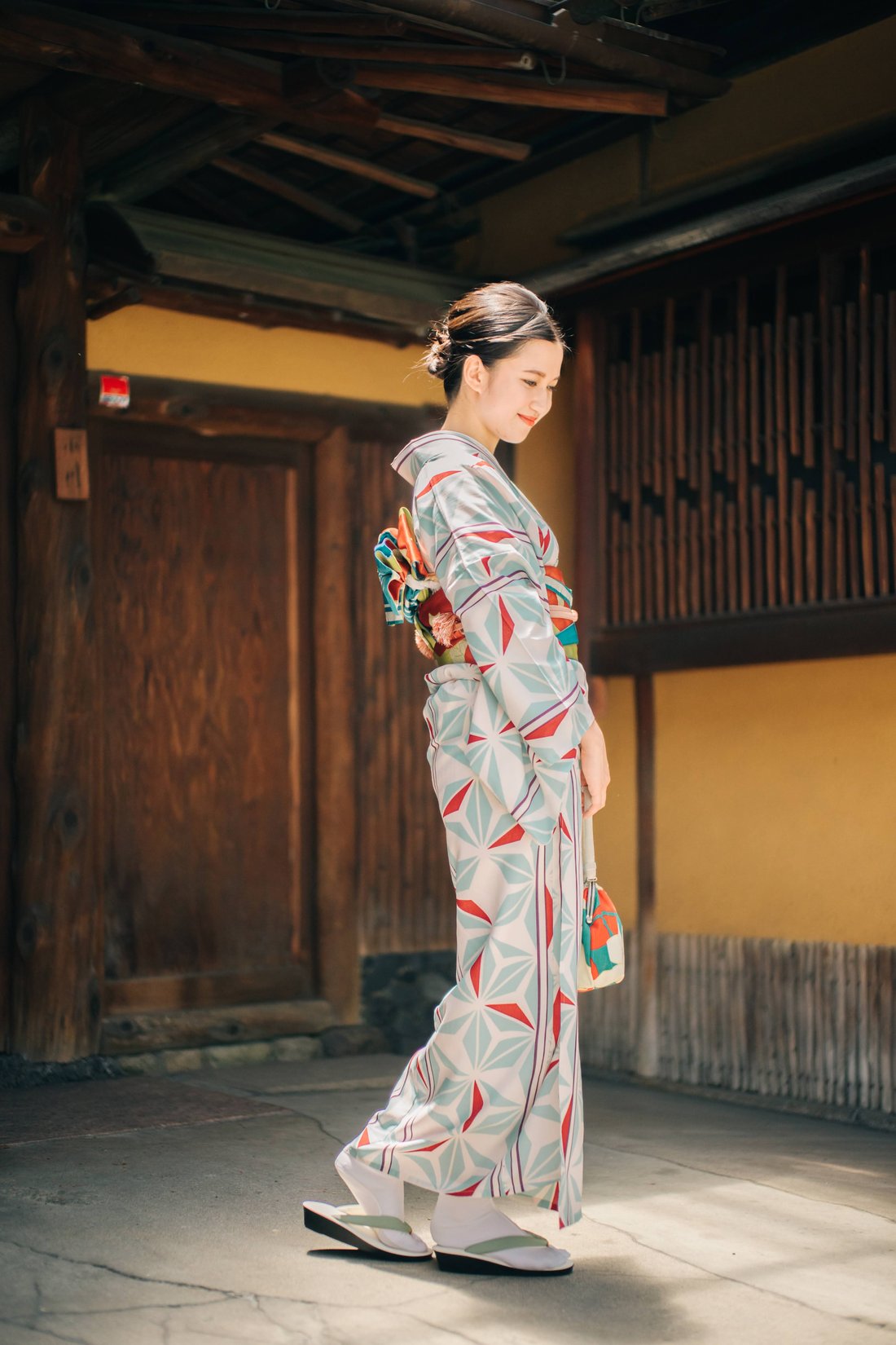 町家の路地を歩く着物姿の女性