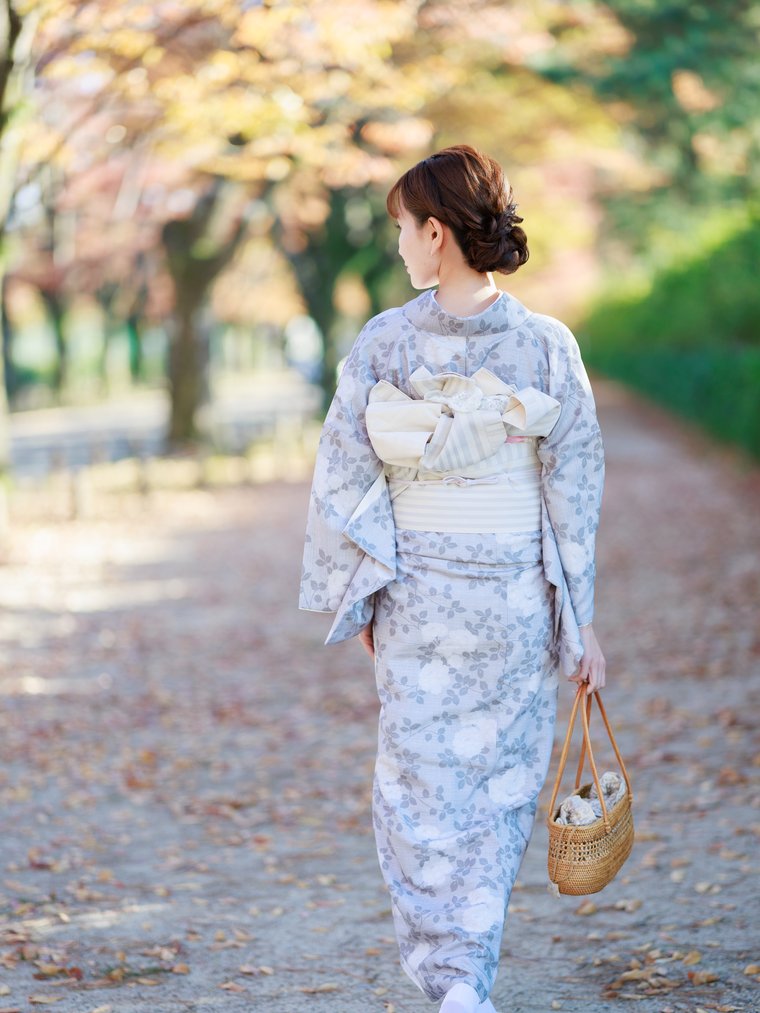 木々の道を歩く着物姿の後ろ姿