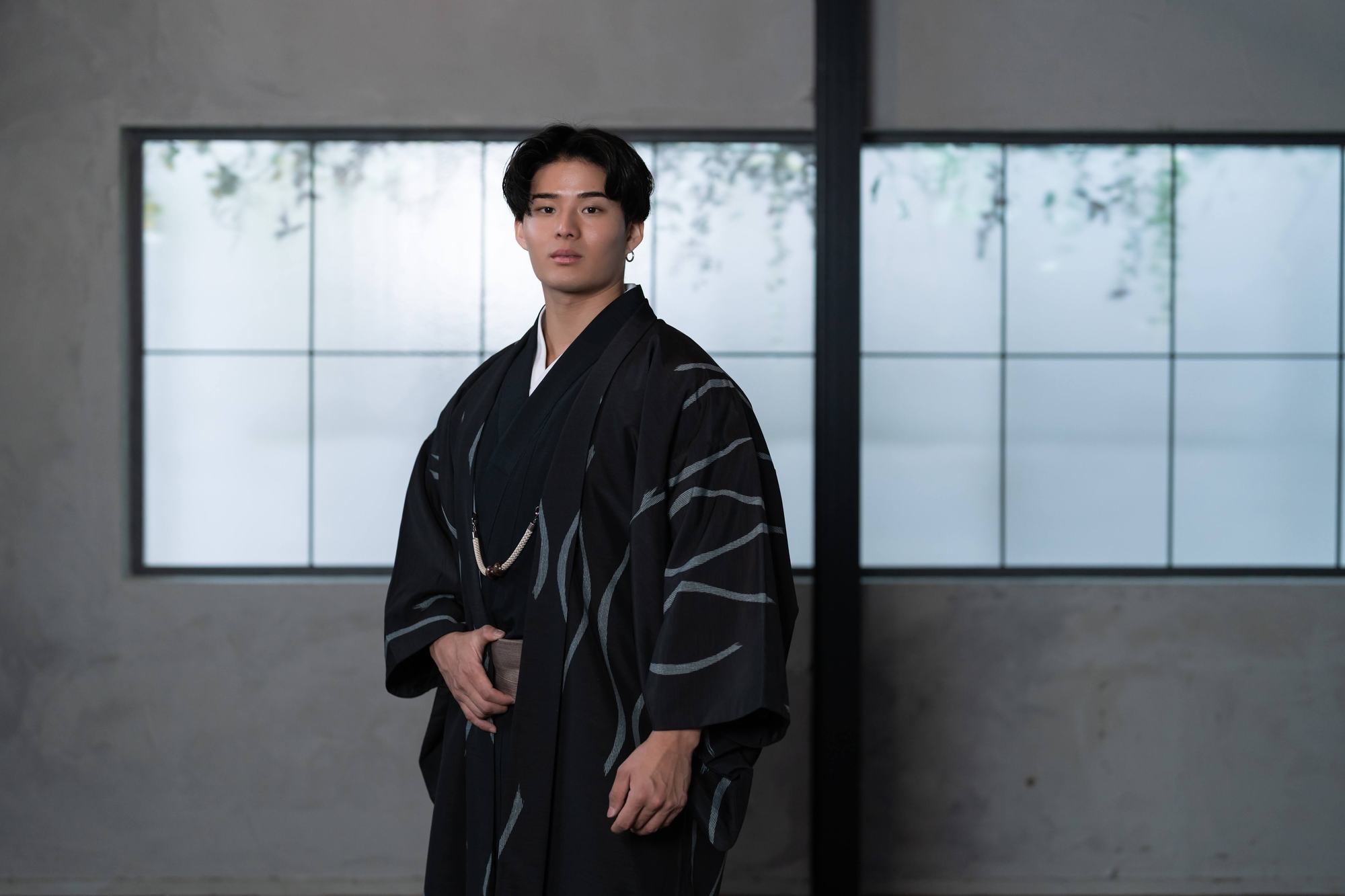 黒の羽織姿で佇む男性