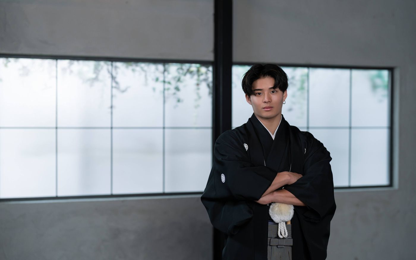 腕を組む紋付羽織袴姿の男性