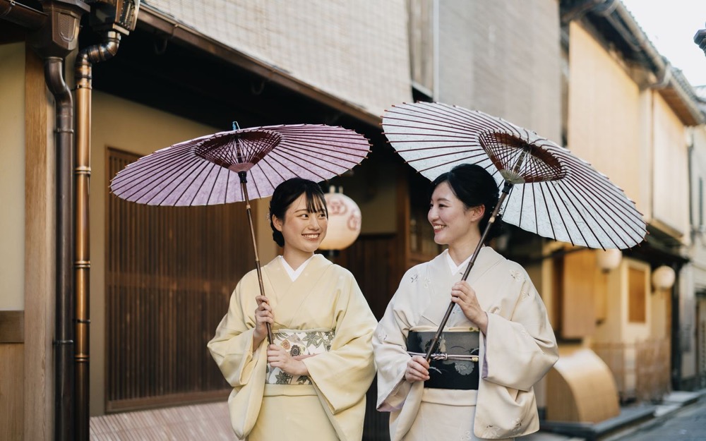 京都の町家の通りを着物で歩くお二人